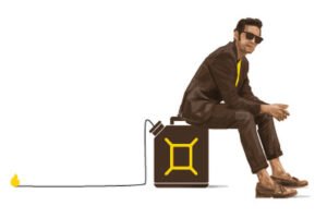 A imagem mostra um homem sentado em um galão de combustível. Ele está vestindo um terno escuro e óculos escuros, com uma camisa amarela. O galão tem um símbolo amarelo e uma mangueira conectada a ele, que se estende até uma pequena chama. O fundo é branco, destacando a figura do homem e o galão.