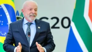 Presidente Lula sorri durante discurso oficial em púlpito; governo federal é criticado por manobras contábeis e aumento da dívida pública.