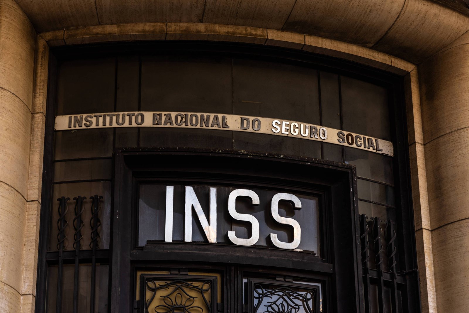 A imagem mostra a entrada de um edifício com a inscrição