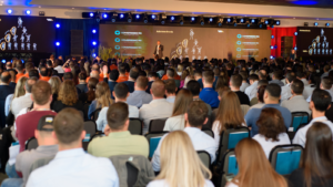Palestrante no palco do Congresso RS diante de auditório lotado, com empresários e líderes assistindo apresentação sobre crescimento e gestão